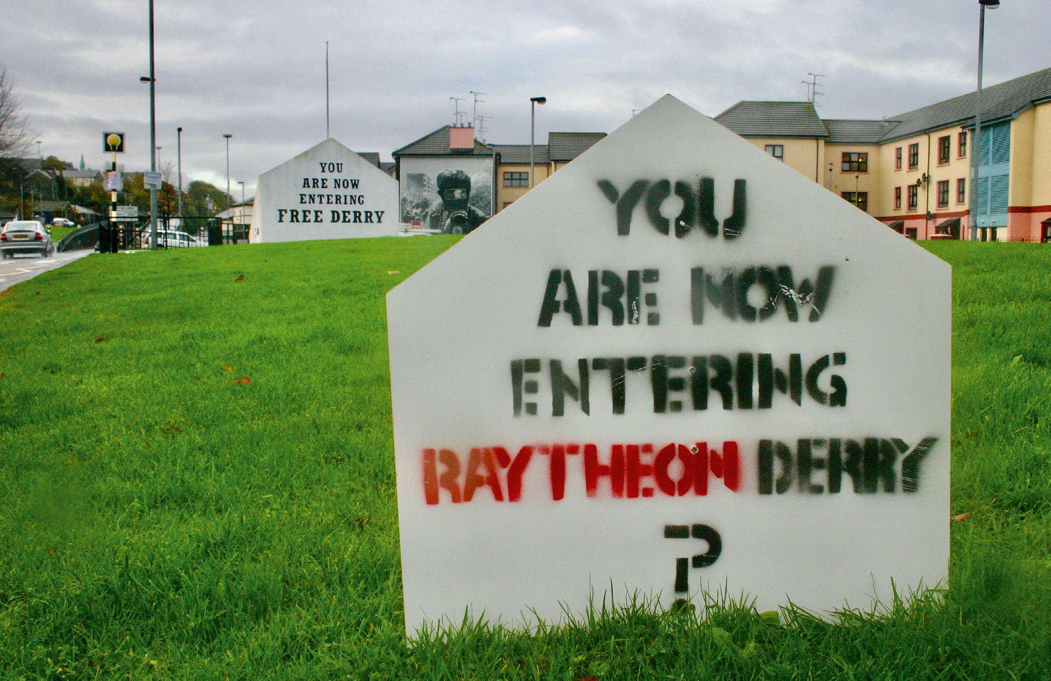 As part of the campaign against Raytheon, signs like this were created – a play on ‘Free Derry Corner’ which can be seen in the background.