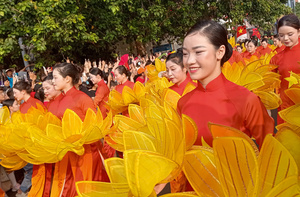 Women with lotus flowers – a national symbol – join the celebrations in Ho Chi Minh city on 30 April 2025. Photo: Tom Fawthrop