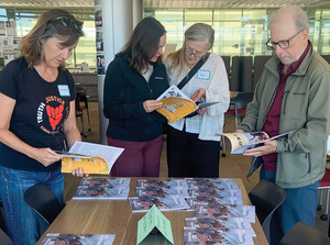 Faculty examine New Internationalist magazine at a teacher training event, San Francisco, 8 November 2025.Photo: K Purcell