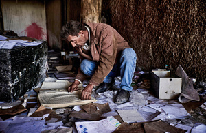 A man digs through documents abandoned in haste at Saydnaya prison in Damascus, Syria, in the hope of tracing missing loved ones on 18 December 2024.Photo: Le Pictorium/Alamy Live News