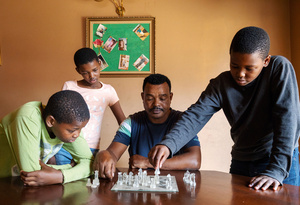 Anti-migrant attacks are reoccurring issue in South Africa. Fikre, an Ethiopian shop owner was a victim of a xenophobic attack in 2023. He’s shown here with his family in the township of Ratanda, south of Johannesburg, in 2025.Photo: Lindokuhle Sobekwa/Magnum Photos