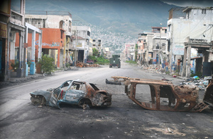 Burned out cars block a street in Port-au-Prince. This shot was taken from inside an armoured police vehicle patrolling a gang-controlled area on 16 January 2026.Photo: Odelyn Joseph/AP Photo/Alamy